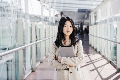 Portrait of young woman standing in city