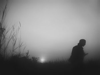 Silhouette man standing on field against clear sky