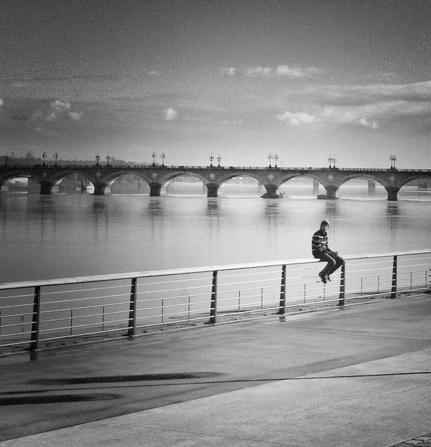 water, full length, lifestyles, leisure activity, rear view, railing, sky, standing, river, built structure, architecture, bridge - man made structure, walking, men, connection, silhouette, pier, sea