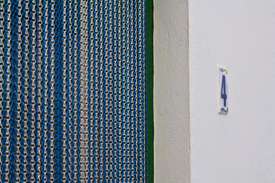 Chains curtain by white wall with number 4