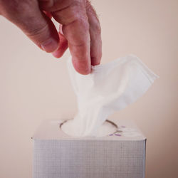 Midsection of woman holding paper against white background