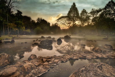 View of rocks in lake during sunrise