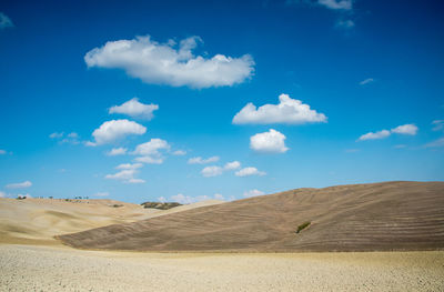 Scenic view of desert against blue sky