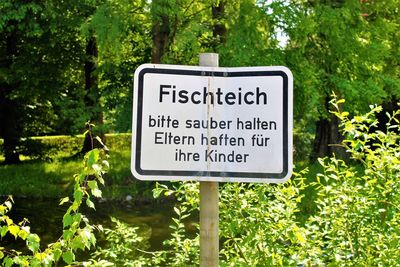 Close-up of road sign against trees