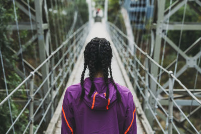 Rear view of woman standing on footbridge