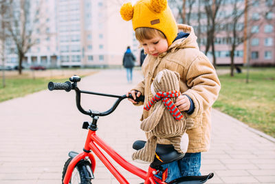 A small child learns to ride a bike for the first time in the city in spring