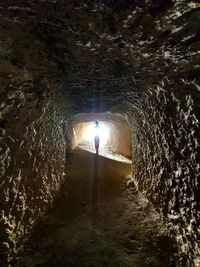 Man standing in illuminated tunnel