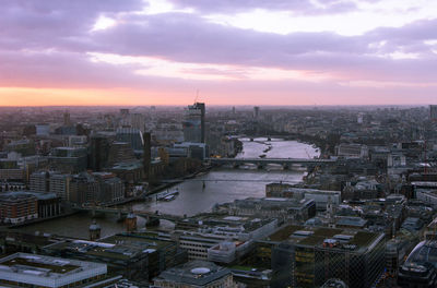 Aerial view of cityscape against cloudy sky