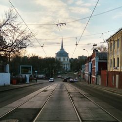 Cars on road in city against sky