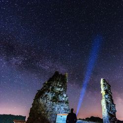 Low angle view of silhouette man standing against star field