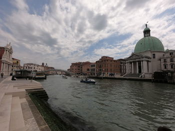 View of buildings in city against cloudy sky