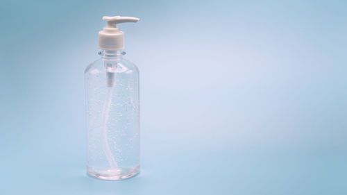 Close-up of glass bottle against blue background