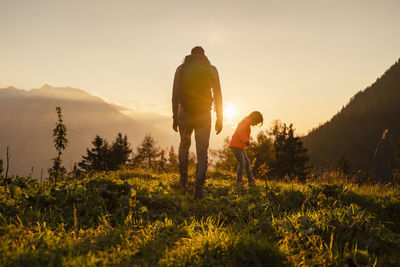 Man with daughter hiking on mountain