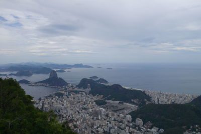 High angle view of townscape by sea against sky