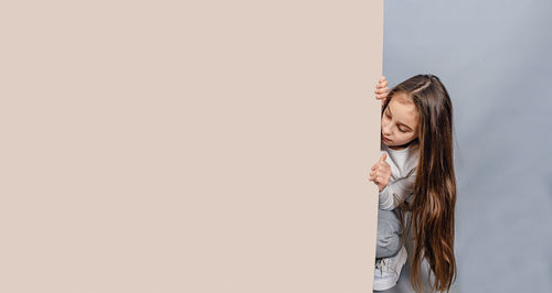 Large sheet of white cardboard. llittle girl and empty banner. advertising.