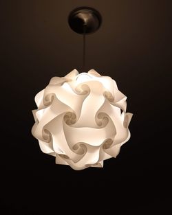 Close-up of illuminated electric lamp against black background