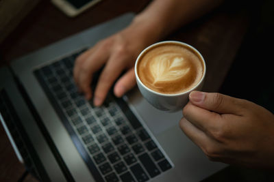 Midsection of woman holding coffee cup