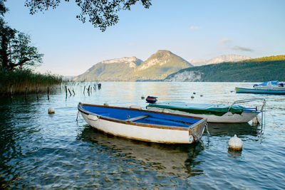 Boats moored in lake against sky