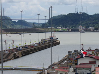 Sailboats on bridge over river against sky