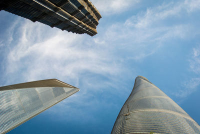 Low angle view of modern buildings against cloudy sky