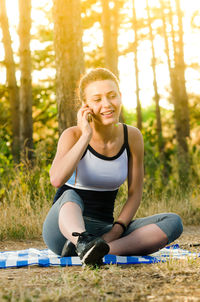 Portrait of smiling young woman sitting on land