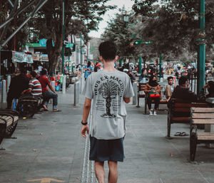 Rear view of people walking on street in city