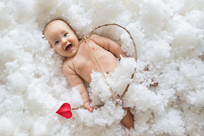 High angle view of happy baby on fluffy bed