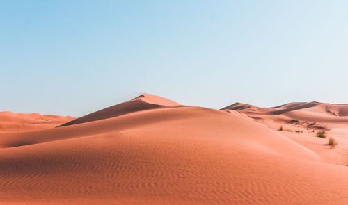 Tranquil view of sand dunes in desert against clear sky