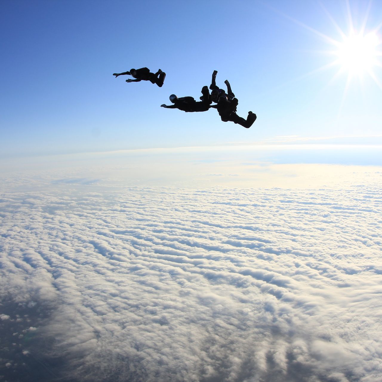 flying, mid-air, sun, sky, sunbeam, sunlight, silhouette, lens flare, beauty in nature, low angle view, scenics, leisure activity, air vehicle, nature, sunset, tranquility, sea, lifestyles