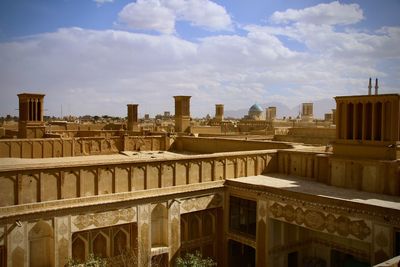 Buildings in city against cloudy sky