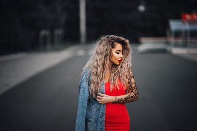 Young woman with long hair standing on road