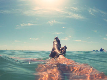 People swimming in sea against sky