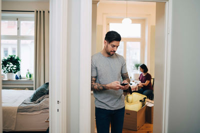 Young man using mobile phone at home