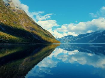 Reflection of the sky and mountains in the blue water of the fjord - eidfjord