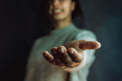 Close-up of woman against black background