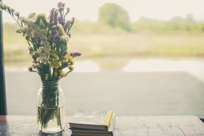 Close-up of plant on table by lake