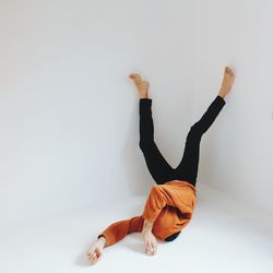Man lying upside down against white background