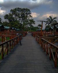 View of boardwalk against cloudy sky