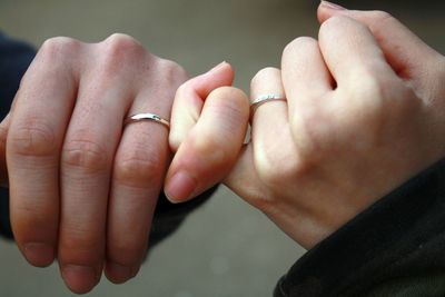 Cropped image of couple holding hands outdoors
