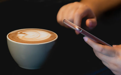 Cropped image of hand holding coffee cup