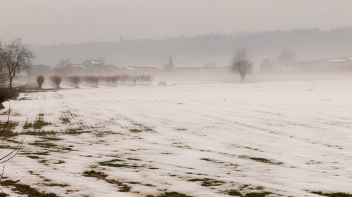 Scenic view of snow covered field against sky