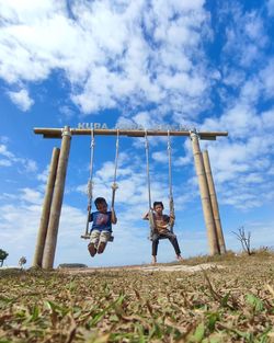 Rear view of woman swinging at playground