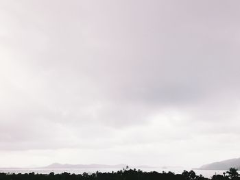 Silhouette trees on landscape against sky