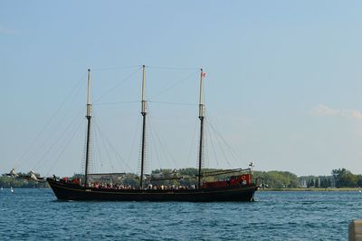 Ship sailing on river against clear sky
