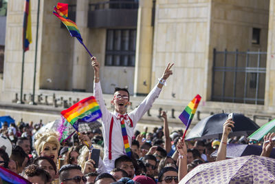 Crowd with rainbow flags in city