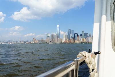 City skyline by river against sky