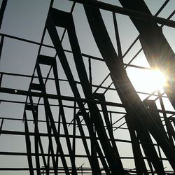 Low angle view of sun shining through built structure