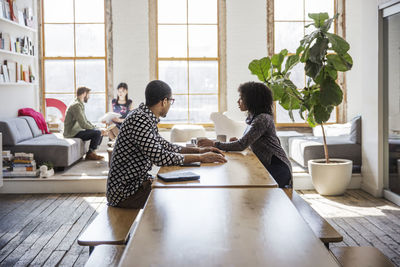 Business people discussing in brightly lit creative office