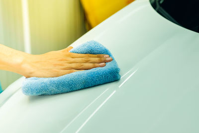 Cropped hand of person cleaning car