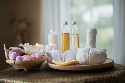 Close-up of spa compress balls and candles on table